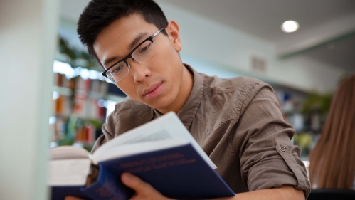 Male student reading book