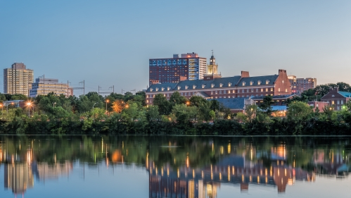 Image from across the Raritan river looking at door buildings in the distance; a dusk photo