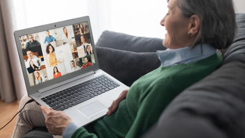 Women on couch watching a virtual meeting