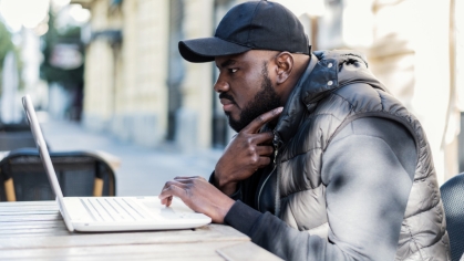 Guy sitting in front of PC at outdoor cafe