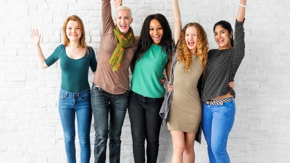 Four women standing in front of white wall