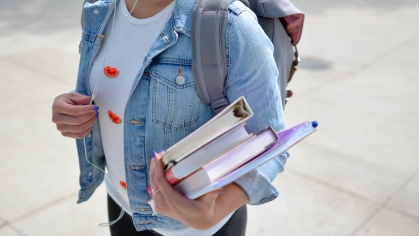 female college student on campus holding books
