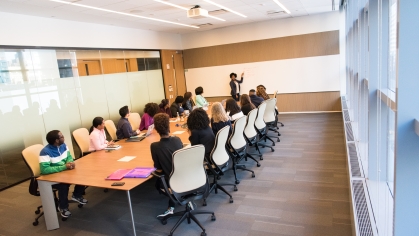 woman presenting to group in conference room