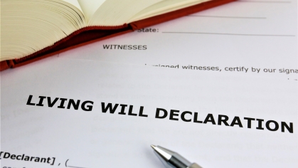 Living will document with book and pen on top