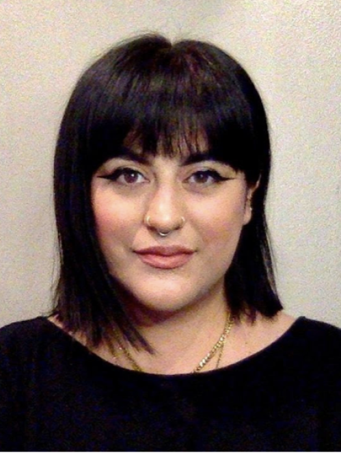 Close cropped photo of a woman with shoulder length dark hair looking directly at the camera