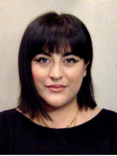 Close cropped photo of a woman with shoulder length dark hair looking directly at the camera