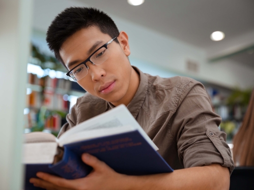 Male student reading book
