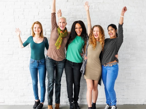 Four women standing in front of white wall