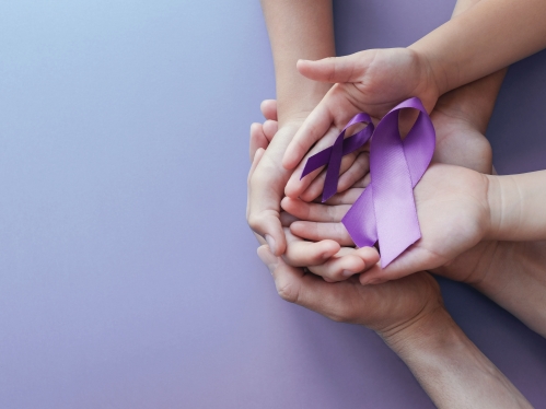 Hands cupping domestic violence ribbon