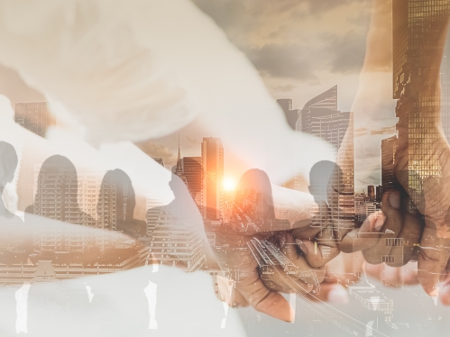 Many hands joining against skyline background