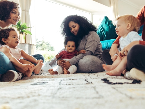 Mothers and babies sitting on rug