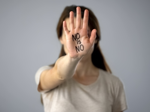 Woman with raised hand with lettering no is no