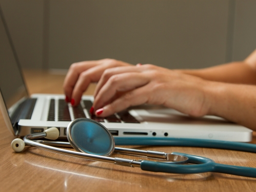 Person on a laptop with a stethoscope
